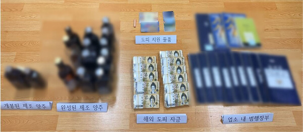 부산경찰청이 가짜 양주 제조·판매 조직을 수사하는 과정에서 압수한 개봉된 양주병과 완성된 가짜 양주, 해외 도피 지원 물품·자금, 업소 내 범행장부 등을 공개하고 있다.(사진_부산경찰청)