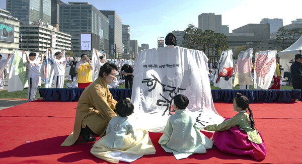 한한국 세계평화작가가 어린이들과 함께 희망대한민국 지도 의상을 들고 무대에 나섰다.(사진_세계평화사랑연맹 제공)
