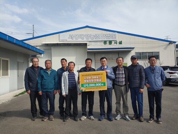 지난 6일 새울원자력본부 관계자와 서생배영농조합 관계자들이 영농자재 지원 전달식에서 1억7000만 원 규모의 지원 내용을 알리며 기념촬영을 하고 있다.(사진_새울원자력본부)