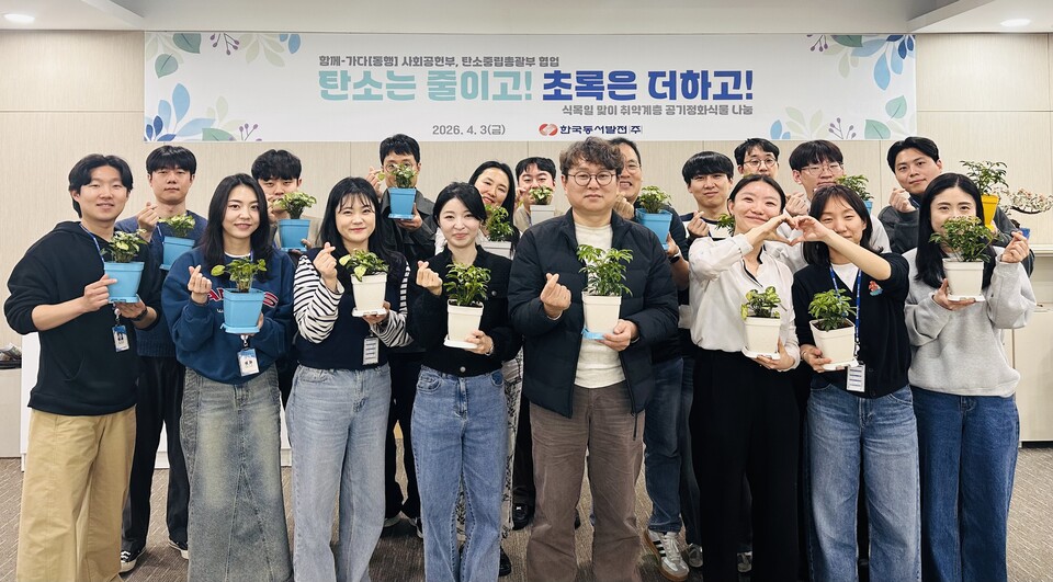 김태준 한국동서발전 사회공헌부장(가운데)과 직원들이 직접 식재한 화분을 들고 기념사진을 촬영하고 있다.(사진_동서발전)