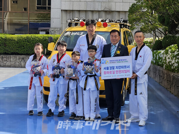 어린이 대상 범죄 및 위험 상황 예방을 위한 서울경찰청 치안파트너 홍보스티커와 경찰홍보인형을 들고 있는 이자형 서울특별시협회장과 지도자, 수련생들 (사진_정연수 기자)
