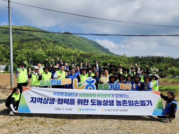 부산환경공단 임직원과 농협 관계자들이 기장군 철마면 농가에서 옥수수 심기 등 농번기 일손 돕기 활동을 하고 기념촬영을 하고 있다.(사진_부산환경공단)