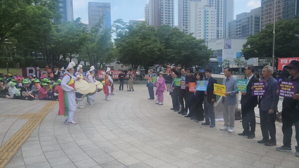 18일 오전 부산지역 시민단체 관계자들이 부산시청 앞 광장에서 풍물패 공연이 진행되는 가운데 황령산 전망대 및 케이블카 조성사업 정상 추진을 촉구하는 손팻말을 들고 있다.(사진_박윤승 기자)